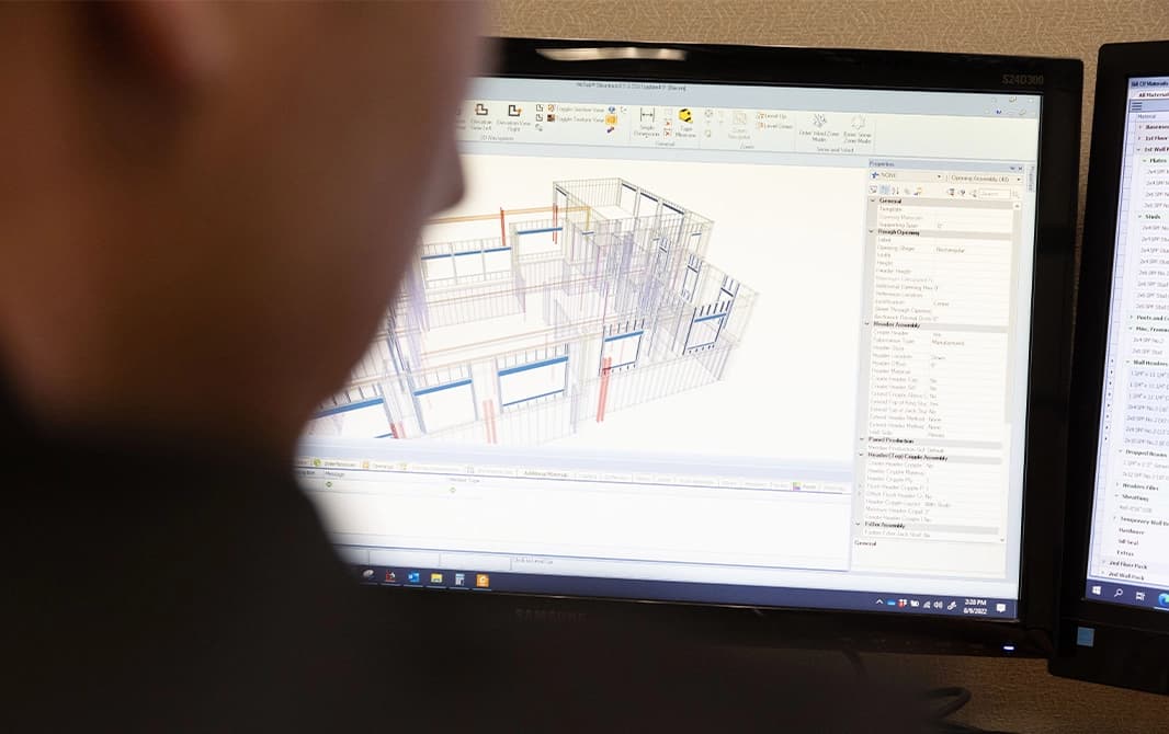 Computer monitors with 3D renderings of construction site.