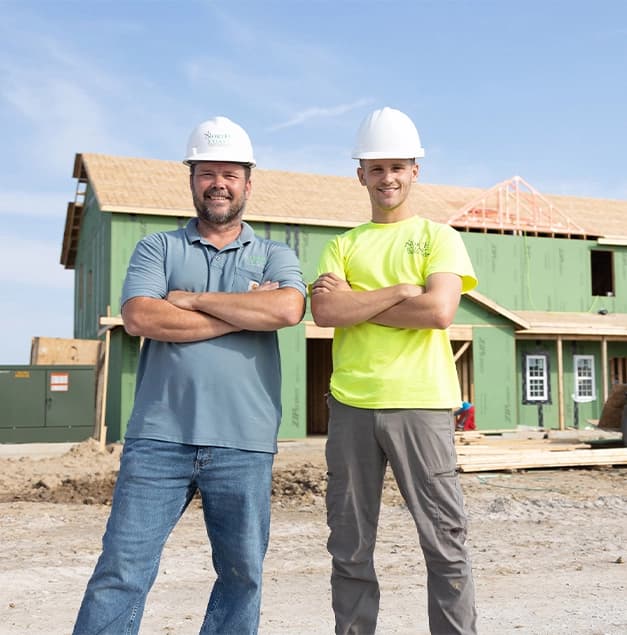 Two contractors working on a residential home building site.