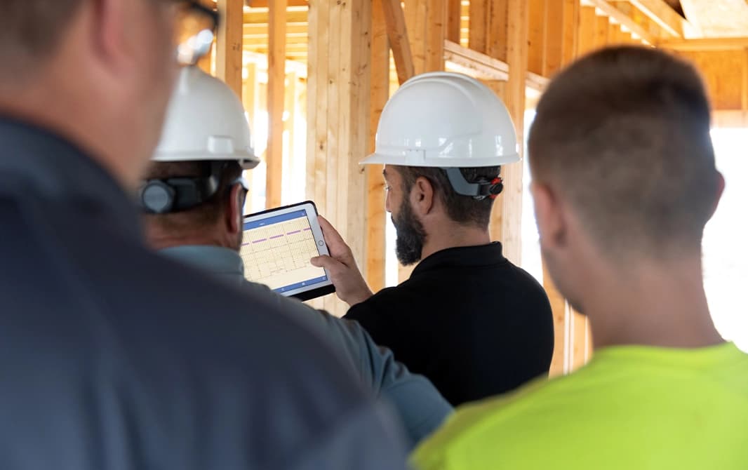 Contractor using a table to share house plans with his crew.