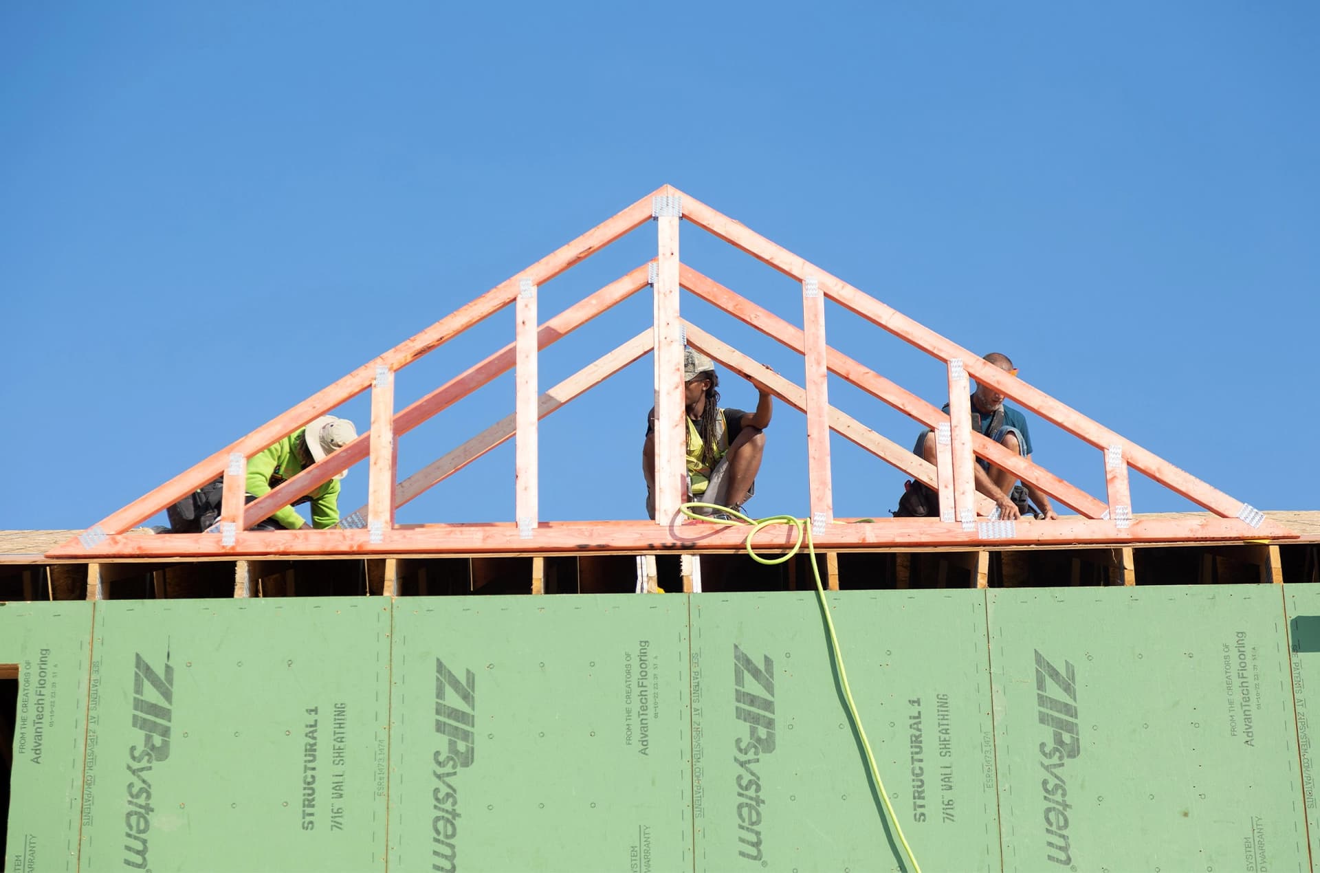 Workers assembling a roof truss.