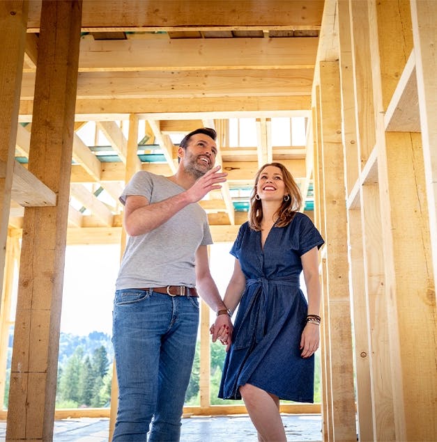 Happy man and women looking at their home building project.