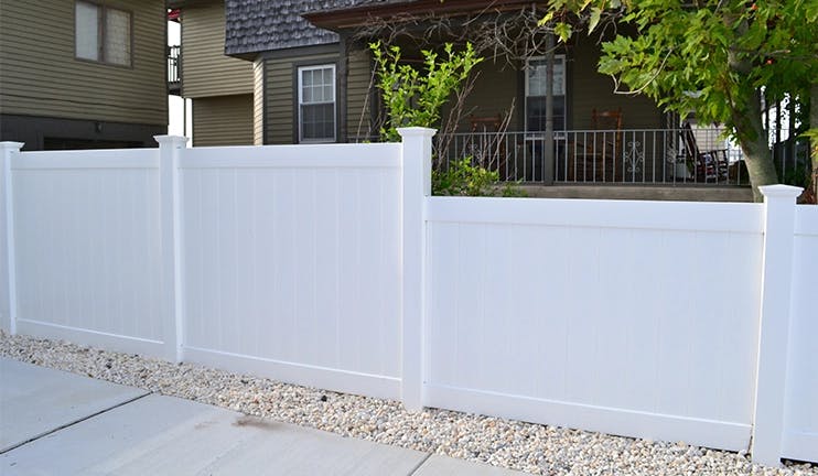 White vinyl fencing in a backyard setting.