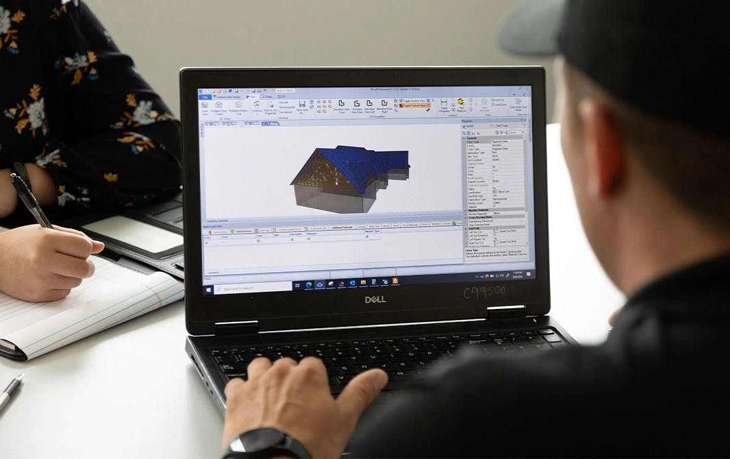 Man looking at computer screen with 3D rendering of a building project.